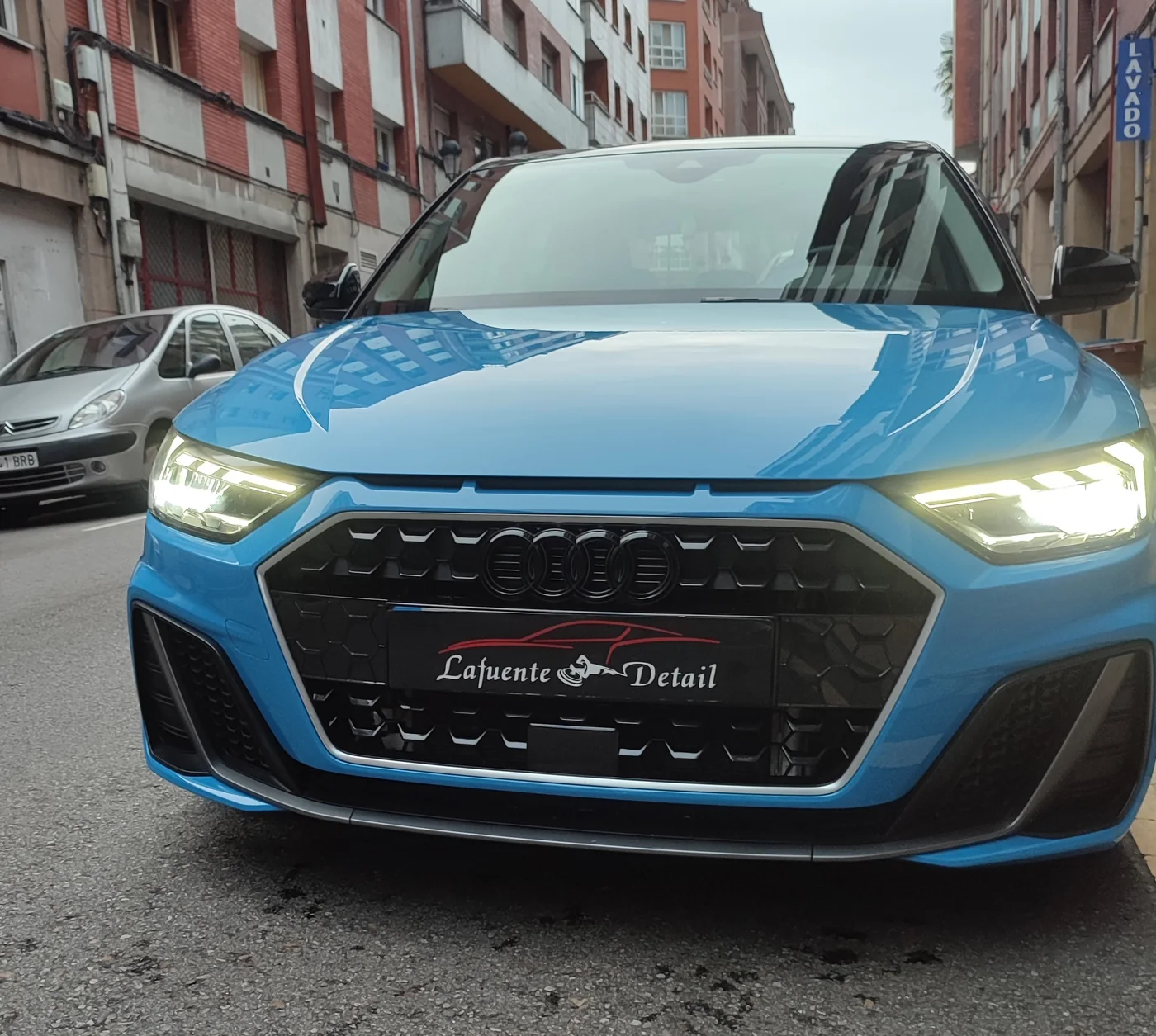 Audi A1 azul visto de frente con la pintura abrillantada y reflejos nítidos en el capó