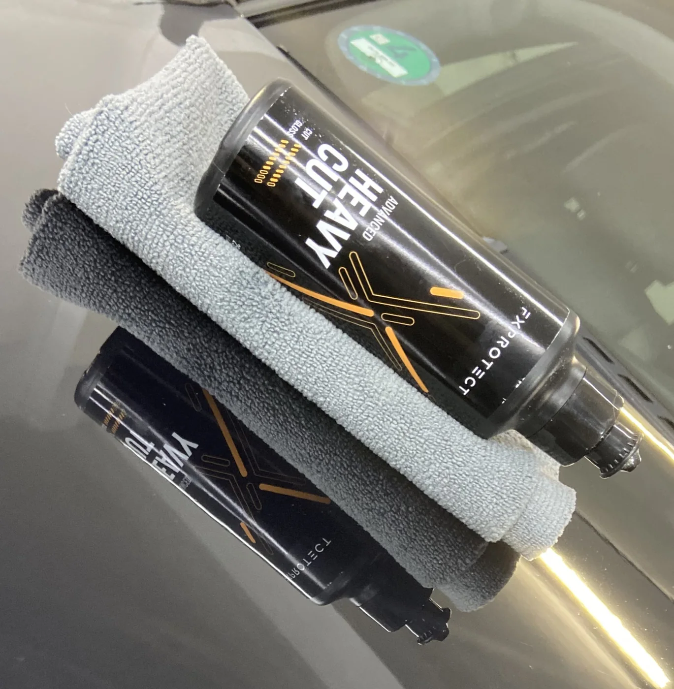 Pulimento FX Protect Heavy Cut y microfibra sobre el capó de un coche durante la corrección de pintura