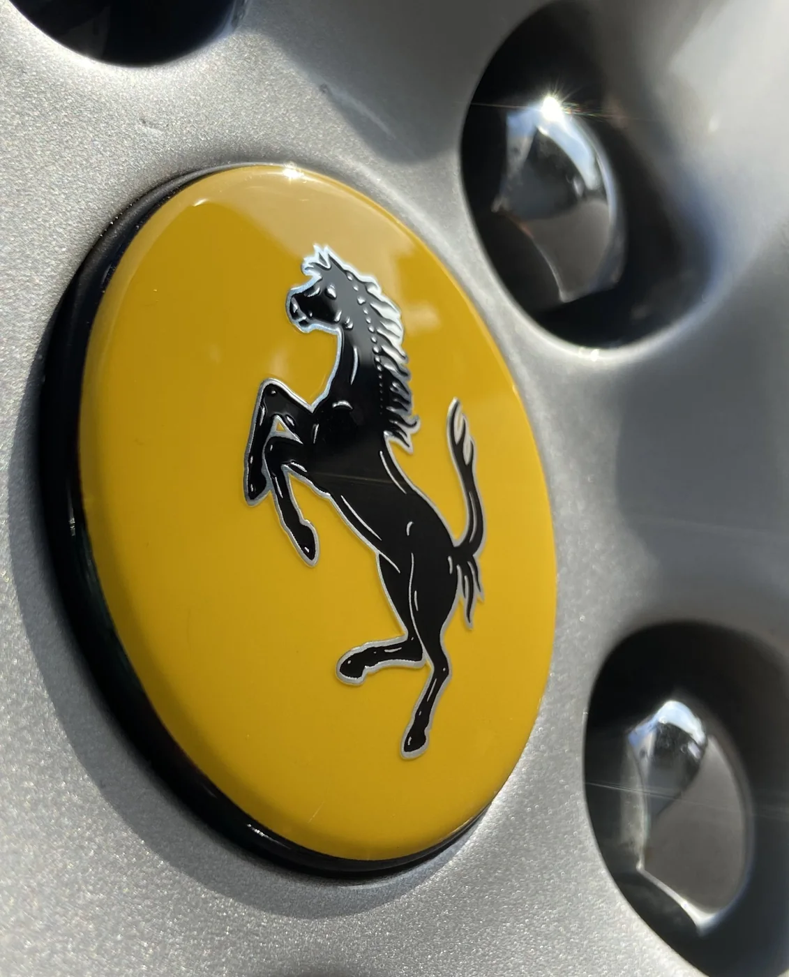Limpieza técnica de detalle y sellado de llantas con emblema de Ferrari clásico