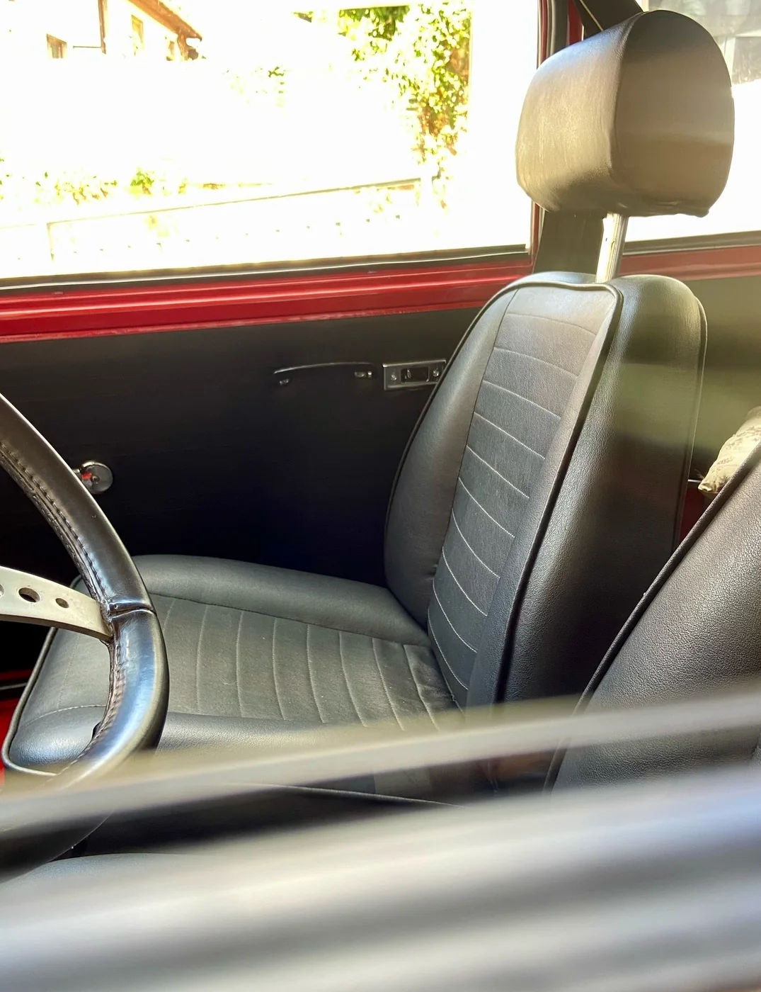 Interior de un Mini 1275 GT clásico con asientos de vinilo negro limpios y acondicionados