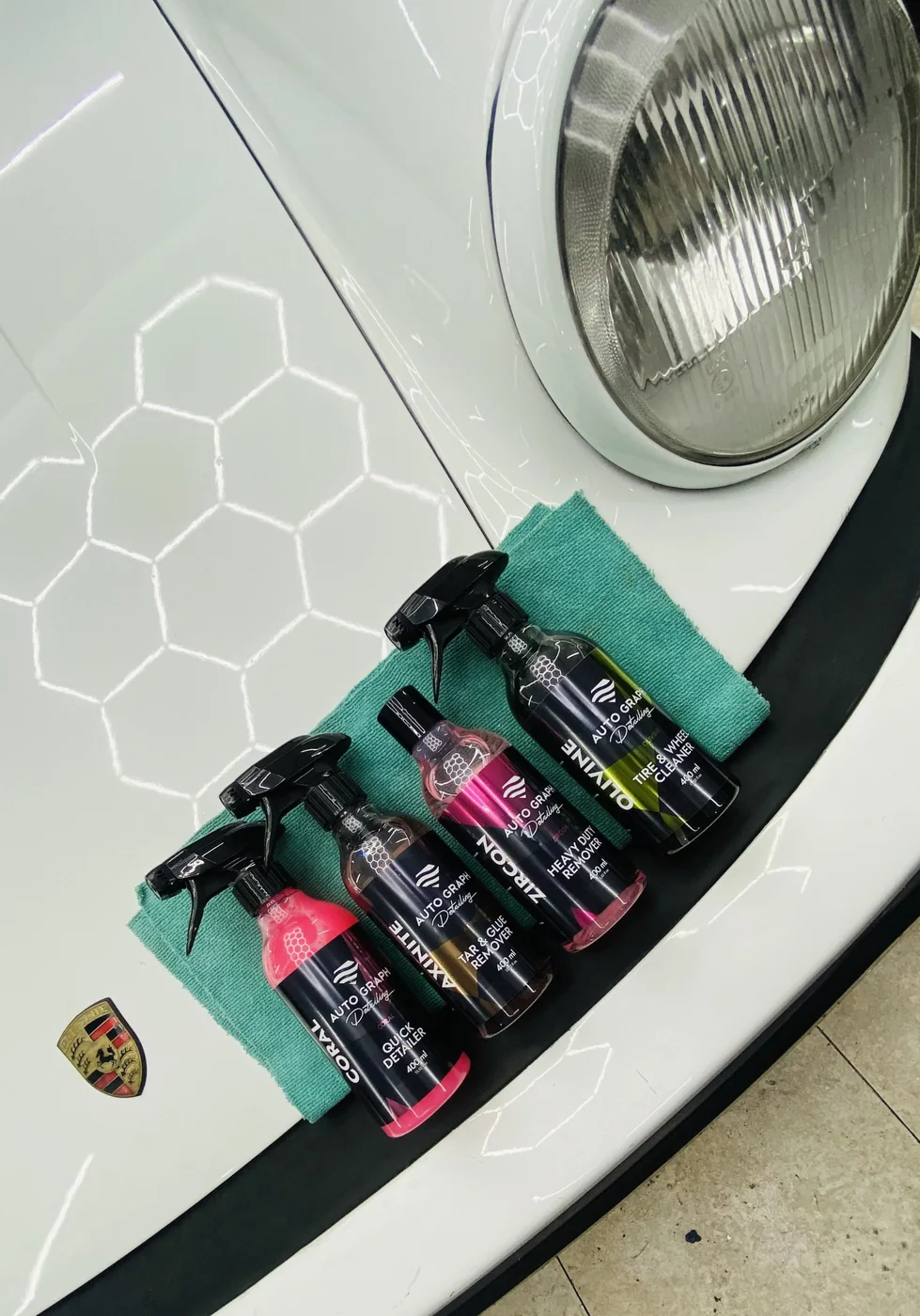 Productos Auto Graph Detailing sobre el capó de un Porsche 911 clásico blanco con la pintura abrillantada