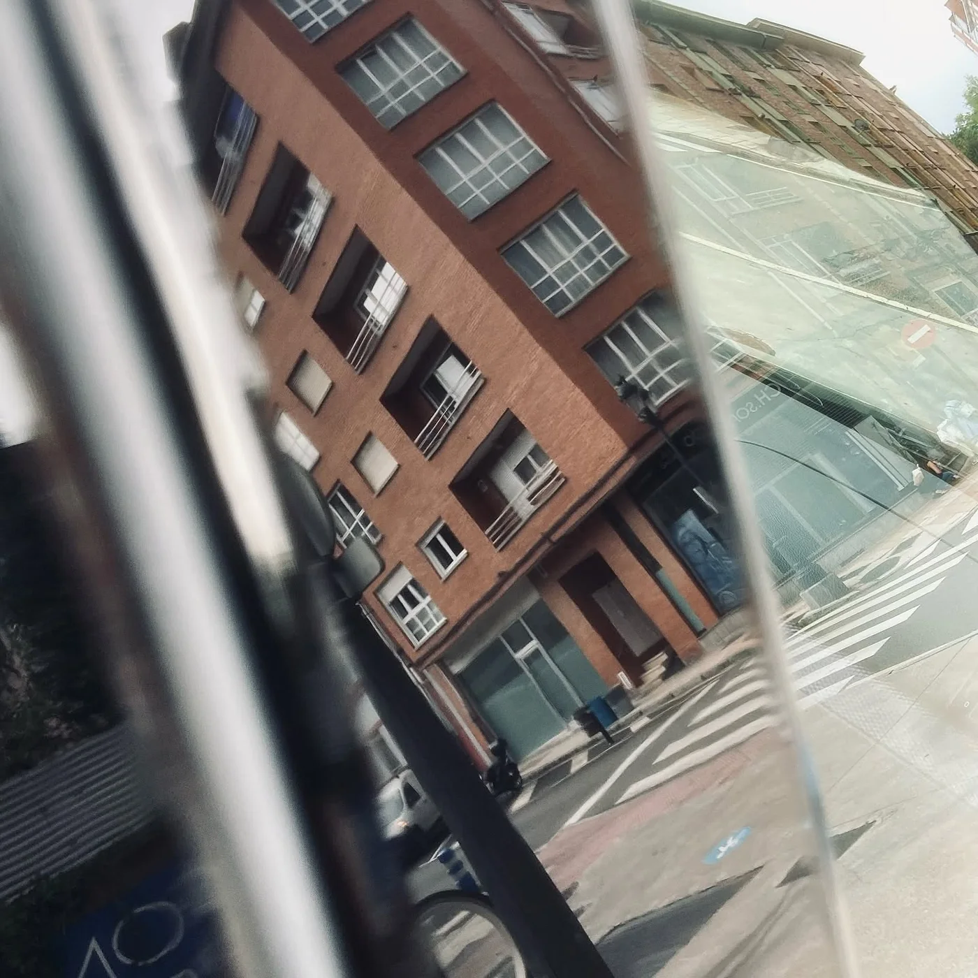 Reflejo nítido de un edificio de Oviedo en una superficie cromada y pulida