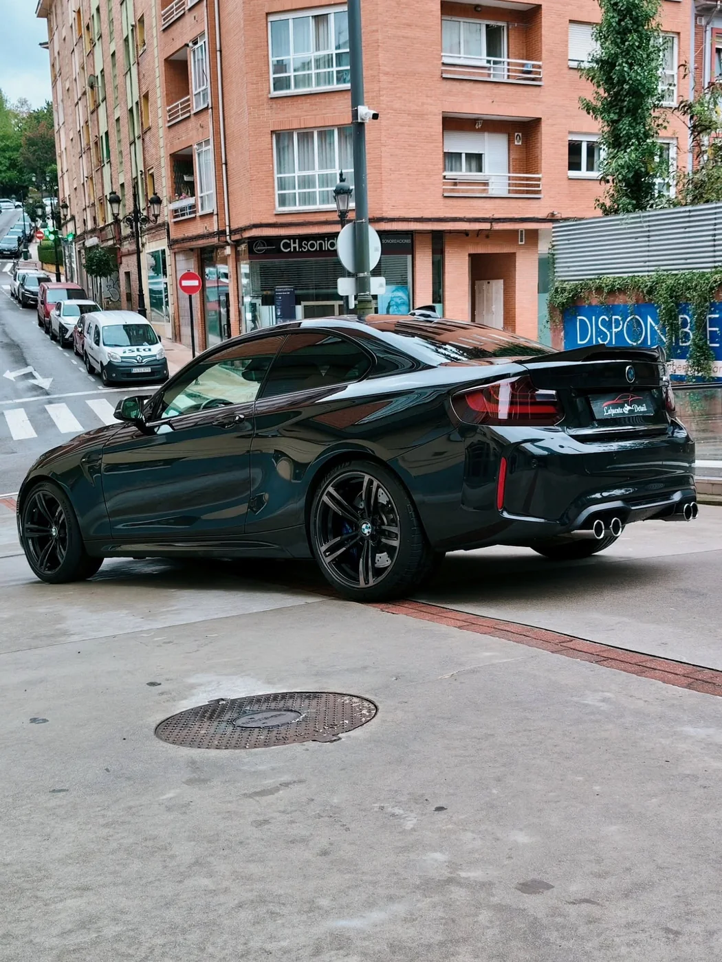 BMW M2 negro visto de tres cuartos por detrás, aparcado en la calle